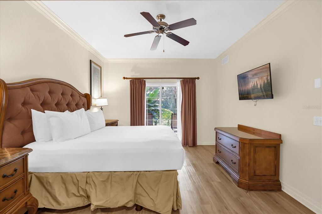 7662 Whisper Way, Unit 103 Reunion, FL 34747 - Photo 12 of 39 a bedroom with a bed and a flat screen tv