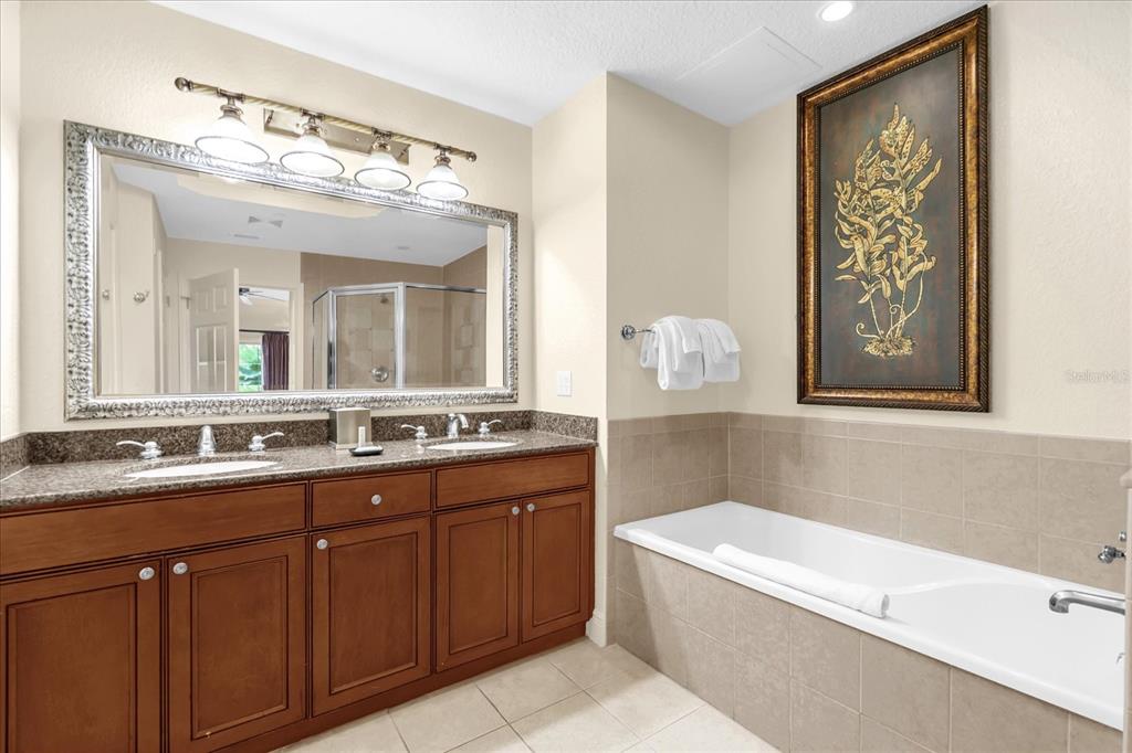7662 Whisper Way, Unit 103 Reunion, FL 34747 - Photo 13 of 39 a bathroom with a tub a sink and mirror