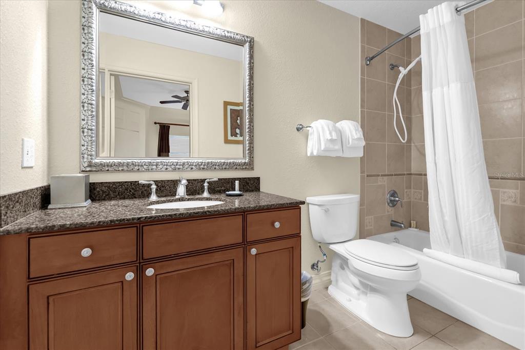 7662 Whisper Way, Unit 103 Reunion, FL 34747 - Photo 20 of 39 a bathroom with a granite countertop sink toilet and shower