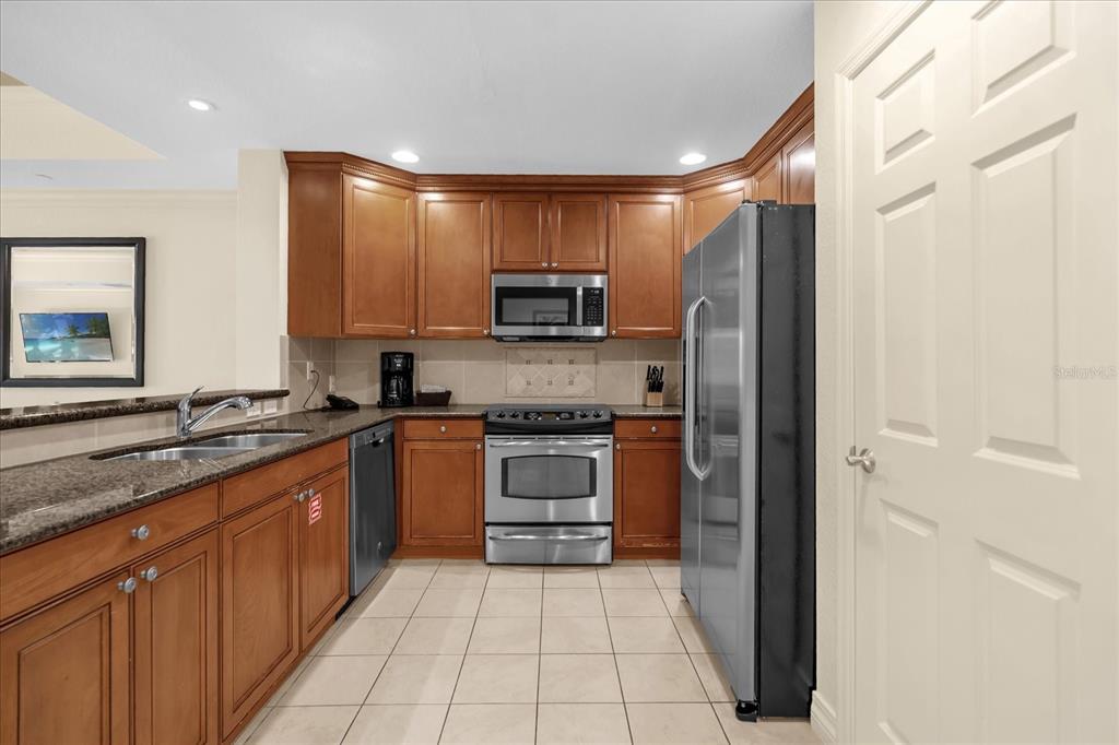 7662 Whisper Way, Unit 103 Reunion, FL 34747 - Photo 2 of 39 a kitchen with stainless steel appliances granite countertop a refrigerator and a stove top oven