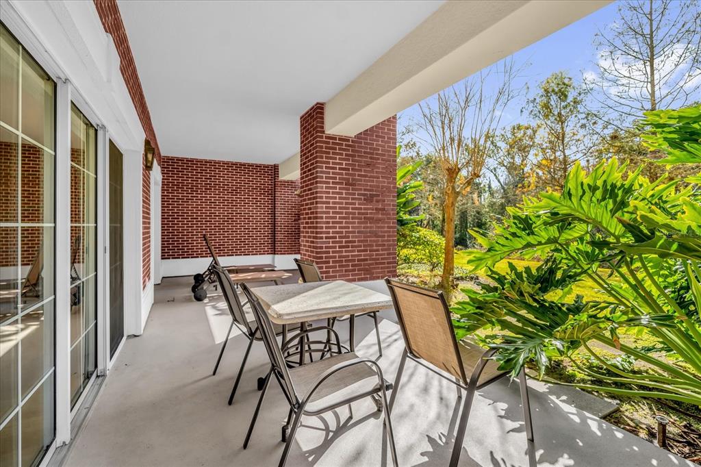 7662 Whisper Way, Unit 103 Reunion, FL 34747 - Photo 22 of 39 a patio with table and chairs and potted plants