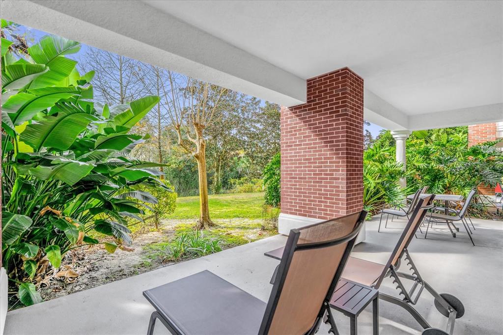 7662 Whisper Way, Unit 103 Reunion, FL 34747 - Photo 24 of 39 a view of a patio with table and chairs and potted plants