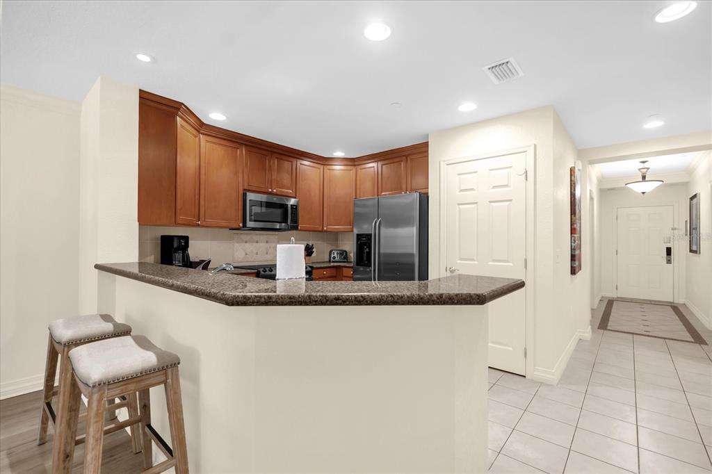 7662 Whisper Way, Unit 103 Reunion, FL 34747 - Photo 3 of 39 a kitchen with stainless steel appliances granite countertop a sink and a refrigerator