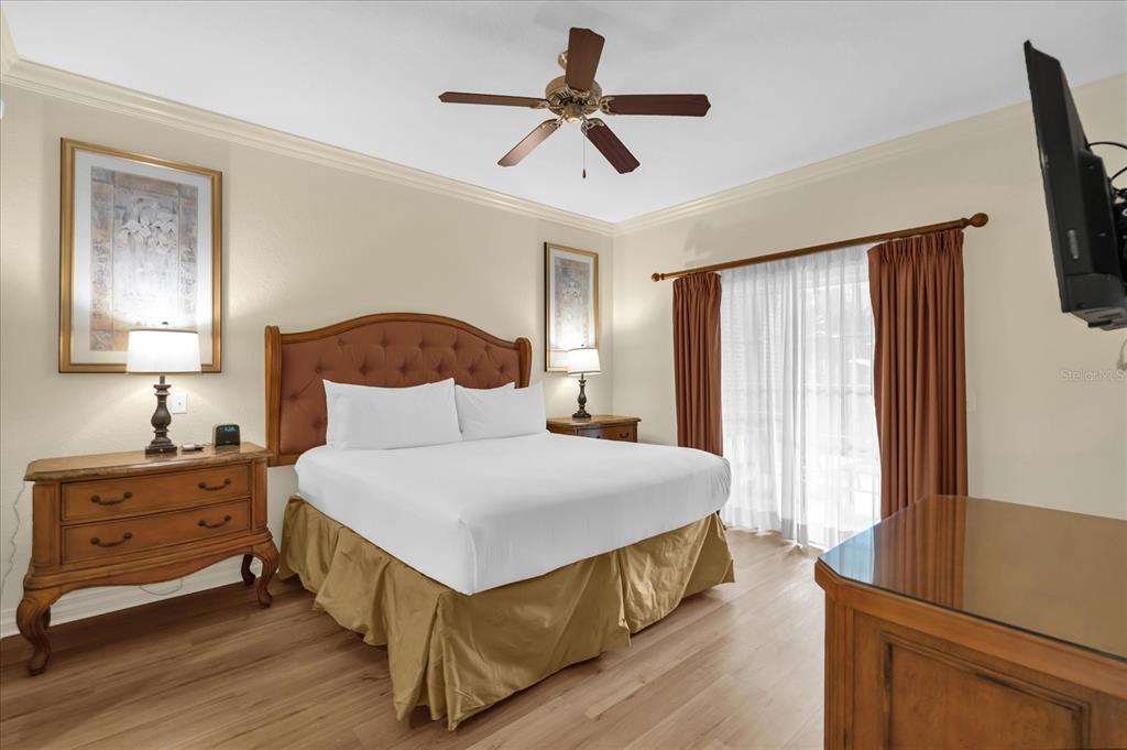 7662 Whisper Way, Unit 103 Reunion, FL 34747 - Photo 10 of 39 a bedroom with a bed and a chandelier