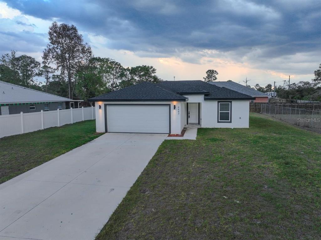 4443 Ferrari Drive Sebring, FL 33872 - Photo 2 of 9 a front view of a house with a yard and garage
