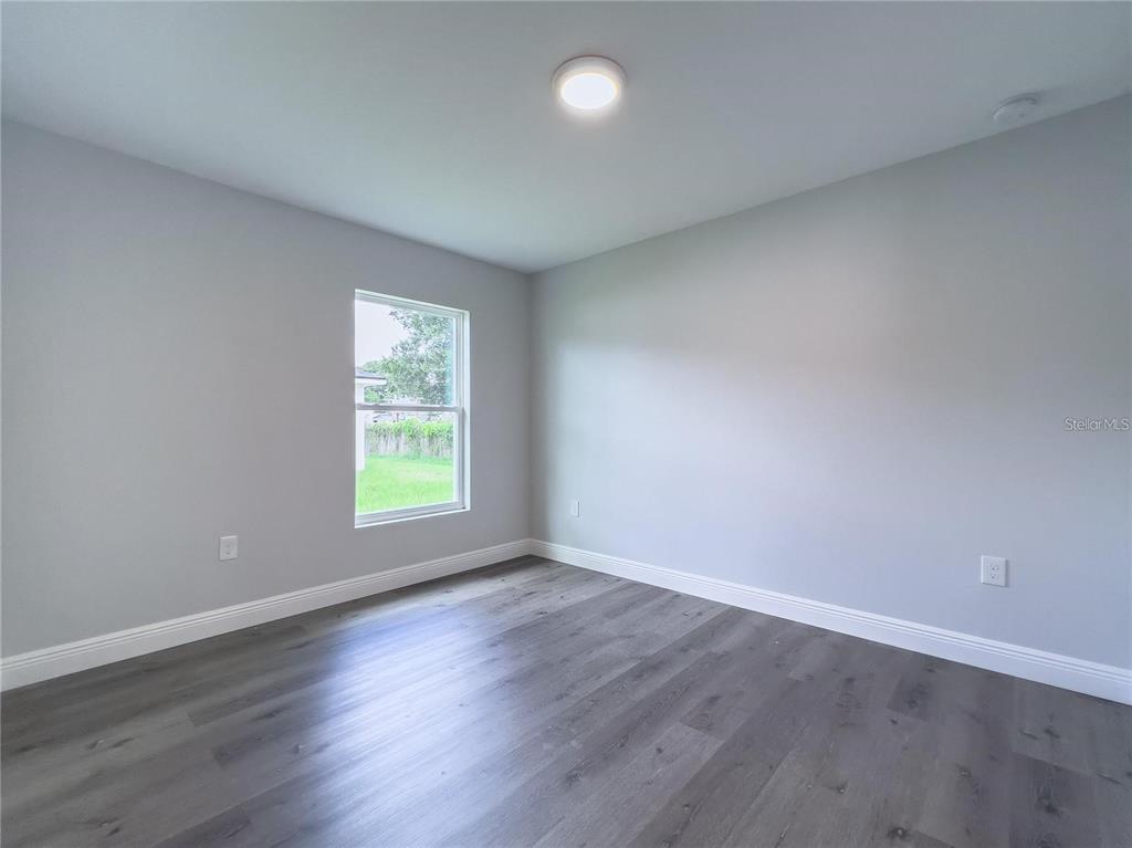 4443 Ferrari Drive Sebring, FL 33872 - Photo 7 of 7 a view of an empty room with wooden floor and a window