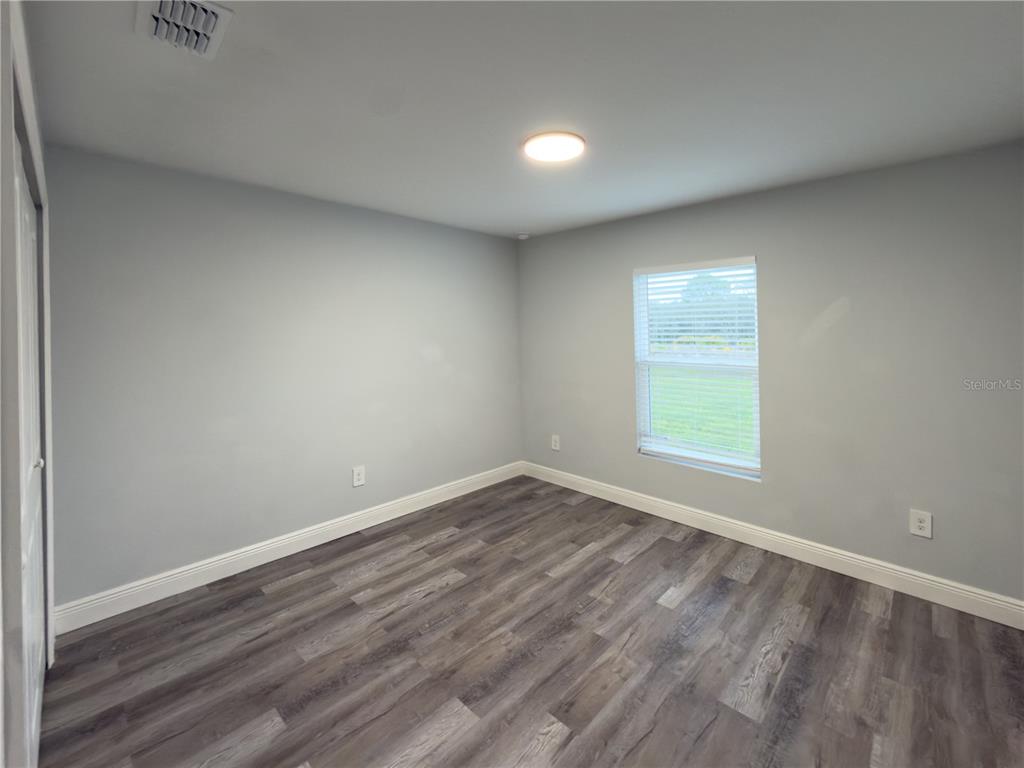 4443 Ferrari Drive Sebring, FL 33872 - Photo 9 of 9 an empty room with wooden floor and windows