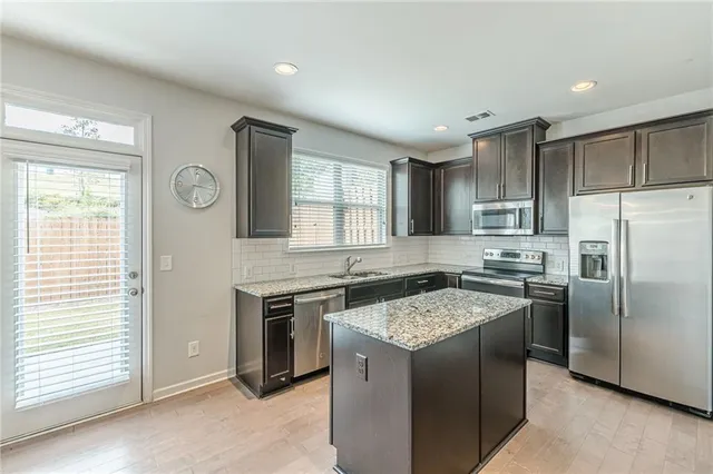 a kitchen with granite countertop a refrigerator and a sink