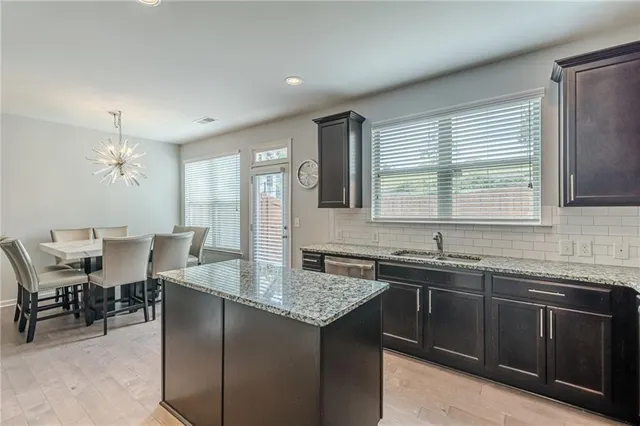 a kitchen with stainless steel appliances granite countertop a sink stove and cabinets