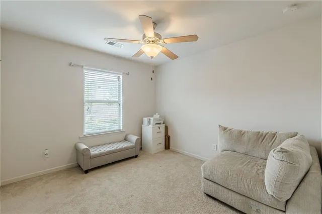 a living room with couch and a ceiling fan
