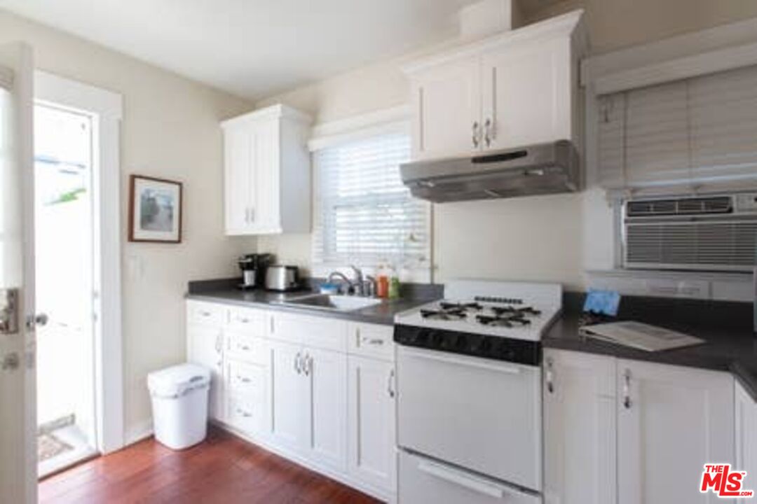 2318 Strongs Drive Venice, CA 90291 - Photo 18 of 19 a kitchen with stainless steel appliances a white stove a sink dishwasher and cabinets with wooden floor
