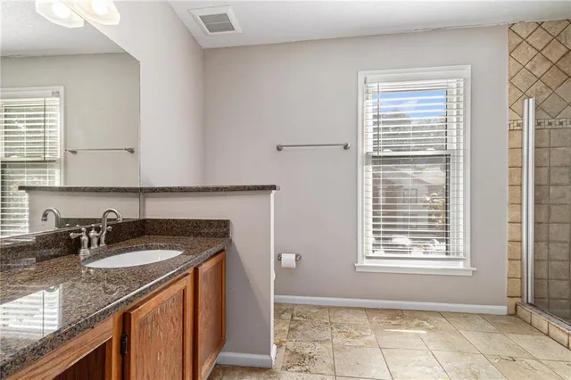 a kitchen with granite countertop a sink stove and cabinets
