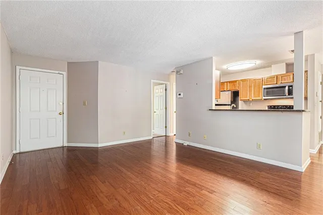 a view of a kitchen with wooden floor and a window