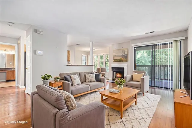 a living room with furniture a large window and a fireplace