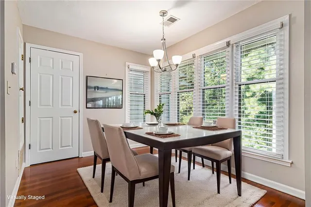 a dining room with furniture a chandelier and wooden floor