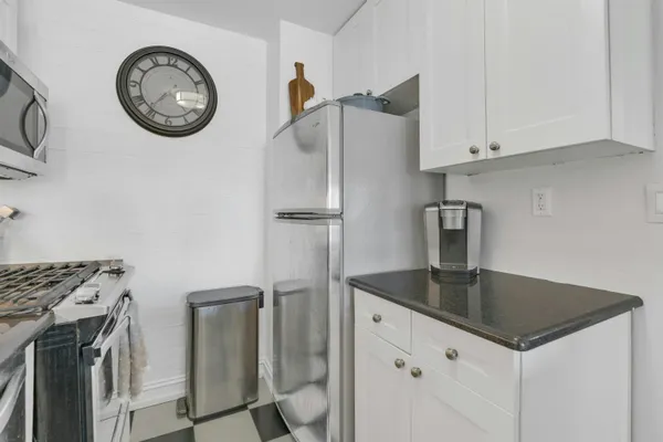 a kitchen with stainless steel appliances granite countertop a sink a stove and a refrigerator