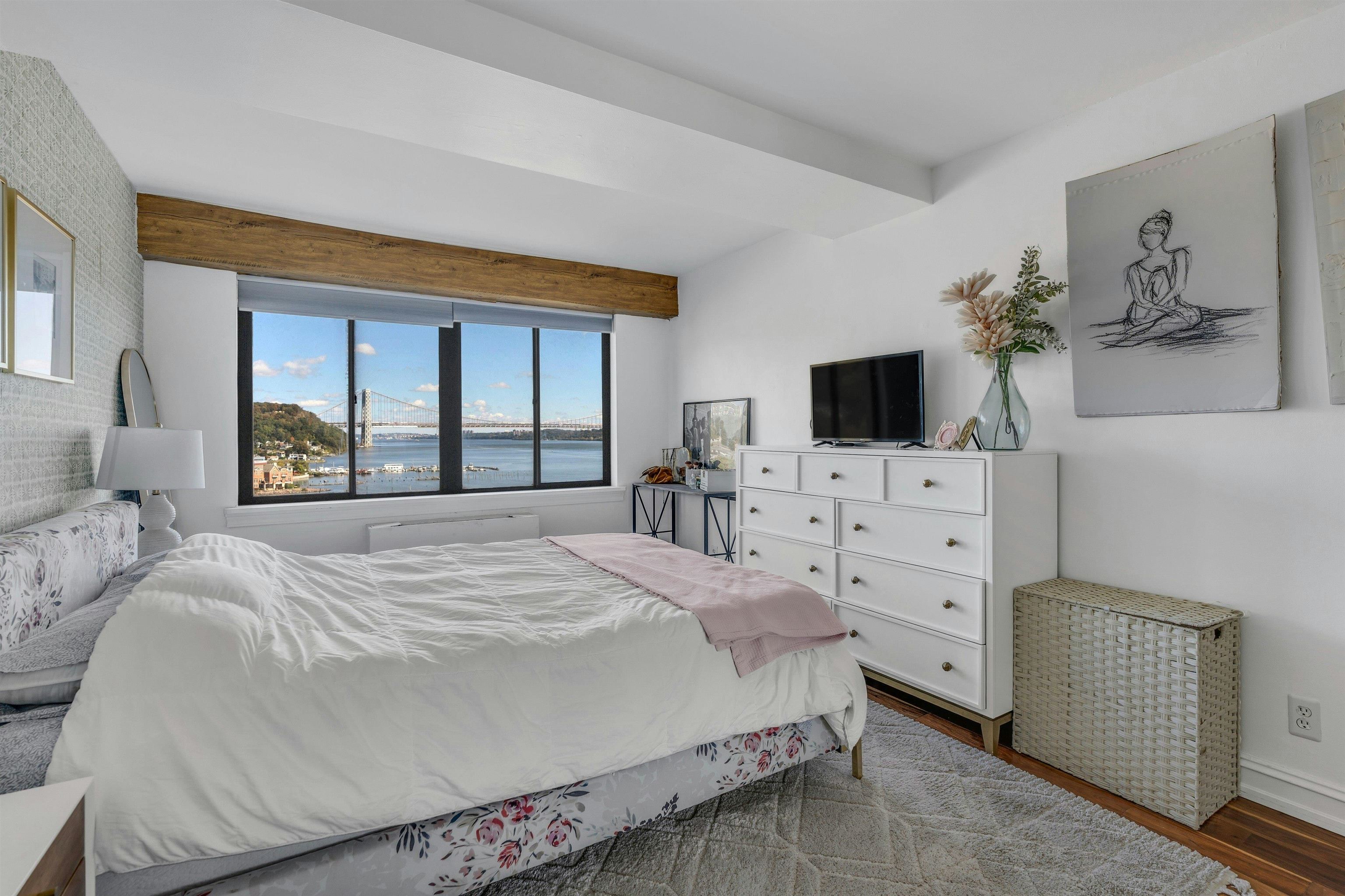 1203 River Road, Unit 9D Edgewater, NJ 07020 - Photo 16 of 28 a bedroom with a bed flat screen tv and a window