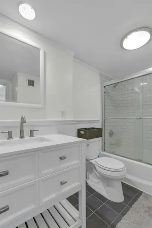 a bathroom with a sink a toilet and a mirror