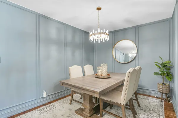 a view of a dining room with furniture a chandelier and wooden floor