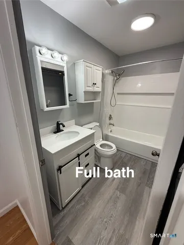 a bathroom with a sink a toilet a mirror and shower