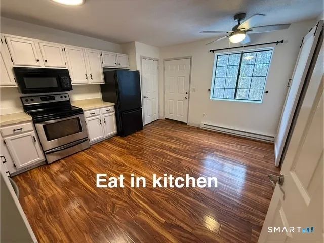 a kitchen with granite countertop stainless steel appliances a stove refrigerator and microwave