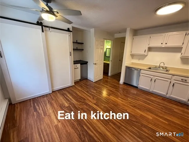 a view of a kitchen with cabinets and wooden floor