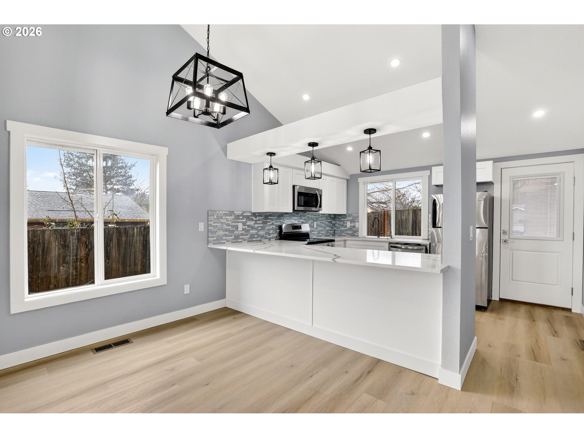 18830 Southwest Butternut Street Beaverton, OR 97078 - Photo 12 of 33 a kitchen with stainless steel appliances granite countertop a stove a refrigerator a sink dishwasher with a dining table and chairs
