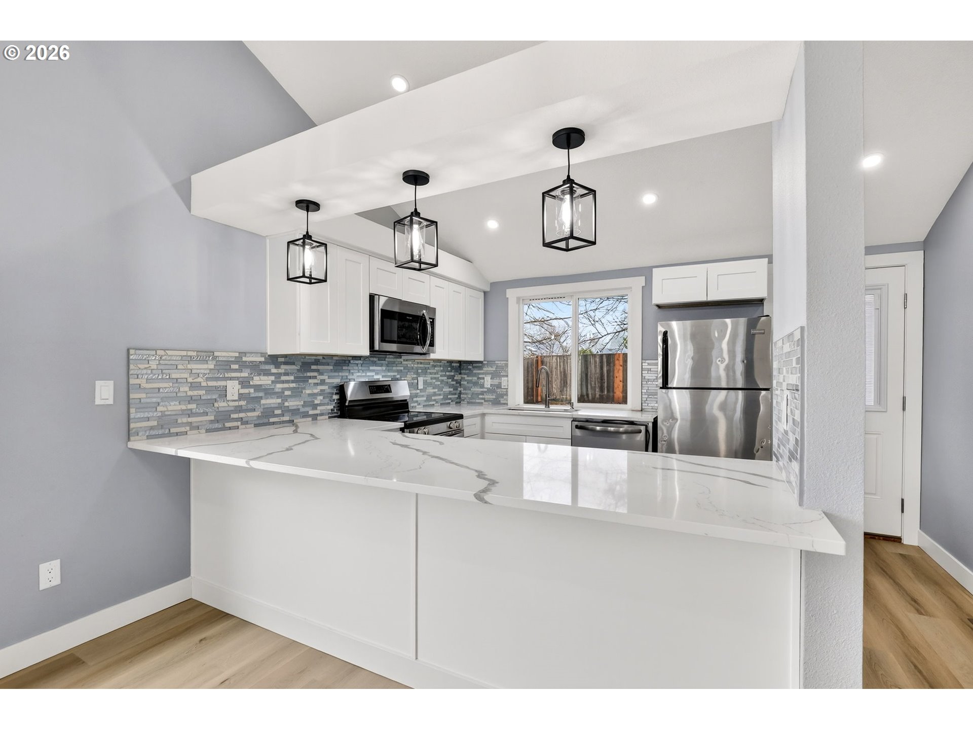 18830 Southwest Butternut Street Beaverton, OR 97078 - Photo 13 of 33 a kitchen with stainless steel appliances kitchen island granite countertop a refrigerator and microwave