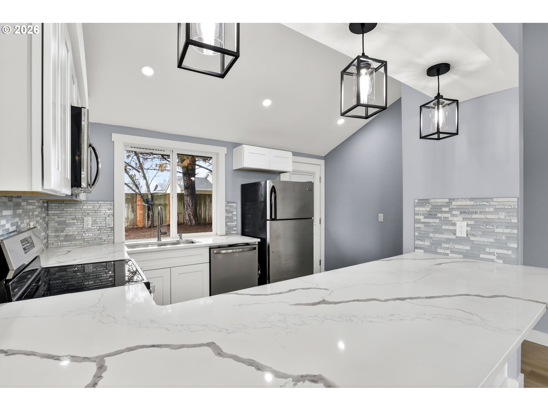 18830 Southwest Butternut Street Beaverton, OR 97078 - Photo 14 of 33 a kitchen with stainless steel appliances kitchen island a refrigerator sink and stove
