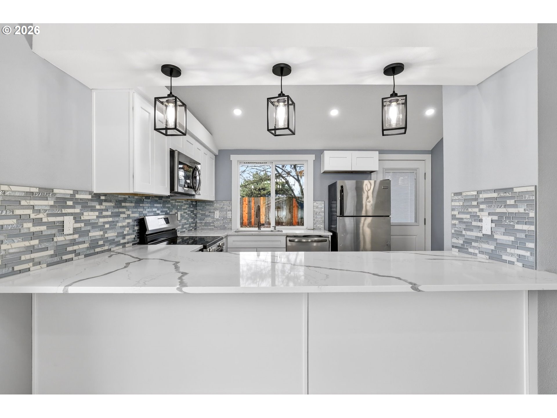 18830 Southwest Butternut Street Beaverton, OR 97078 - Photo 15 of 33 a kitchen with stainless steel appliances granite countertop a sink refrigerator and cabinets