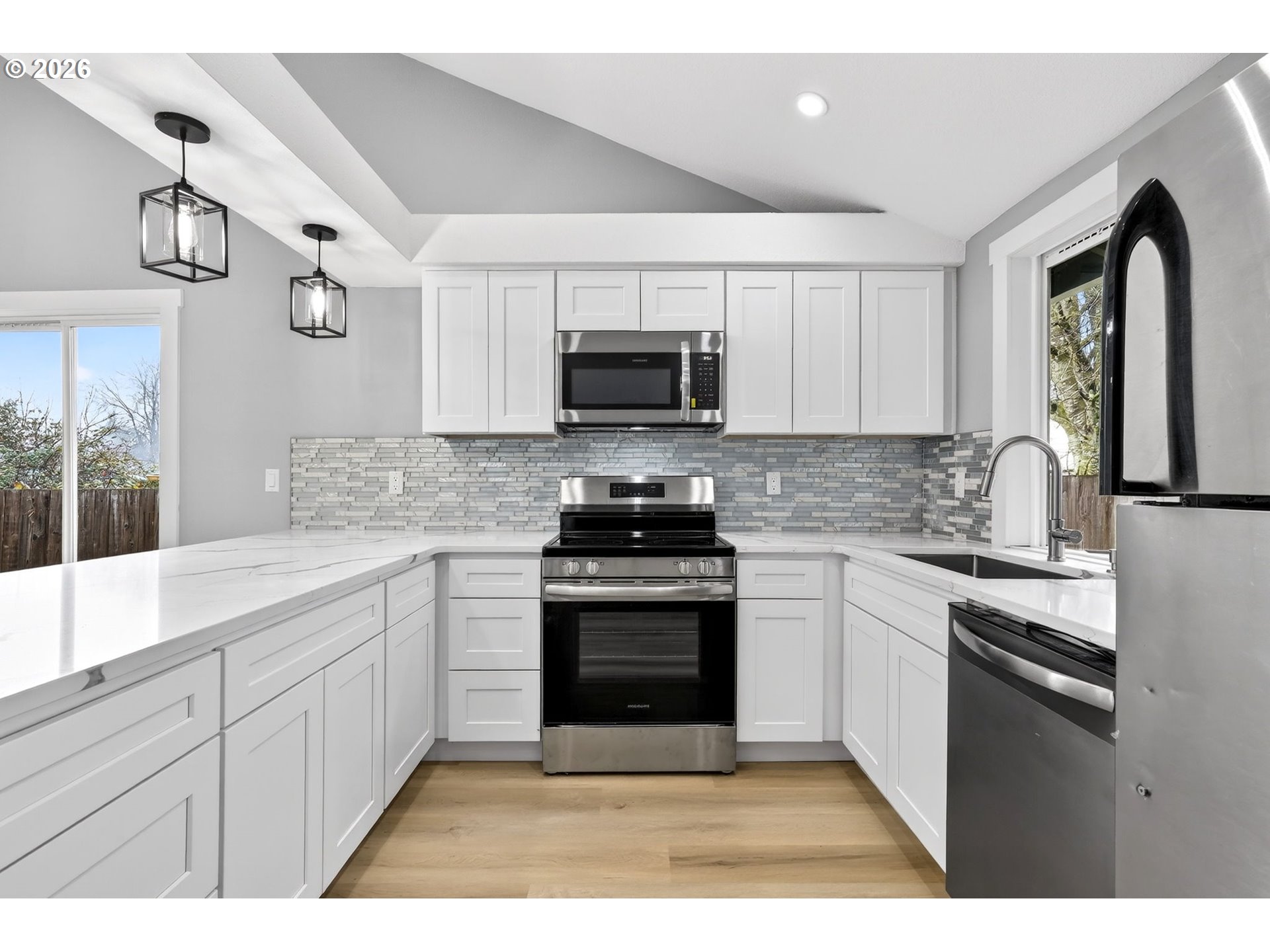 18830 Southwest Butternut Street Beaverton, OR 97078 - Photo 16 of 33 a kitchen with stainless steel appliances granite countertop a stove a sink and a microwave