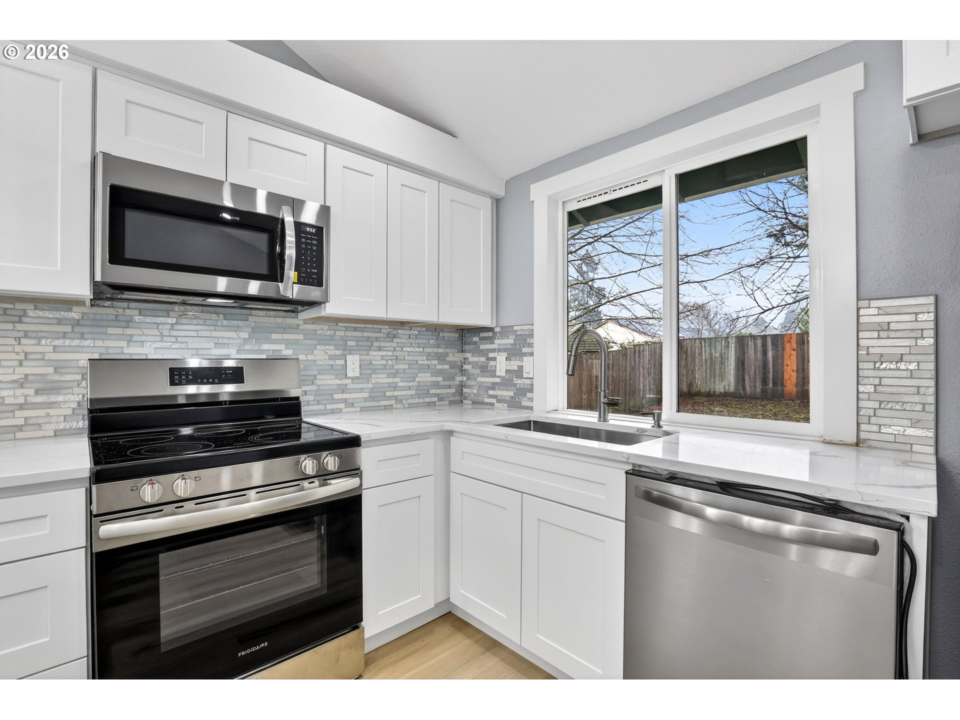 18830 Southwest Butternut Street Beaverton, OR 97078 - Photo 18 of 33 a kitchen with stainless steel appliances a stove microwave and sink