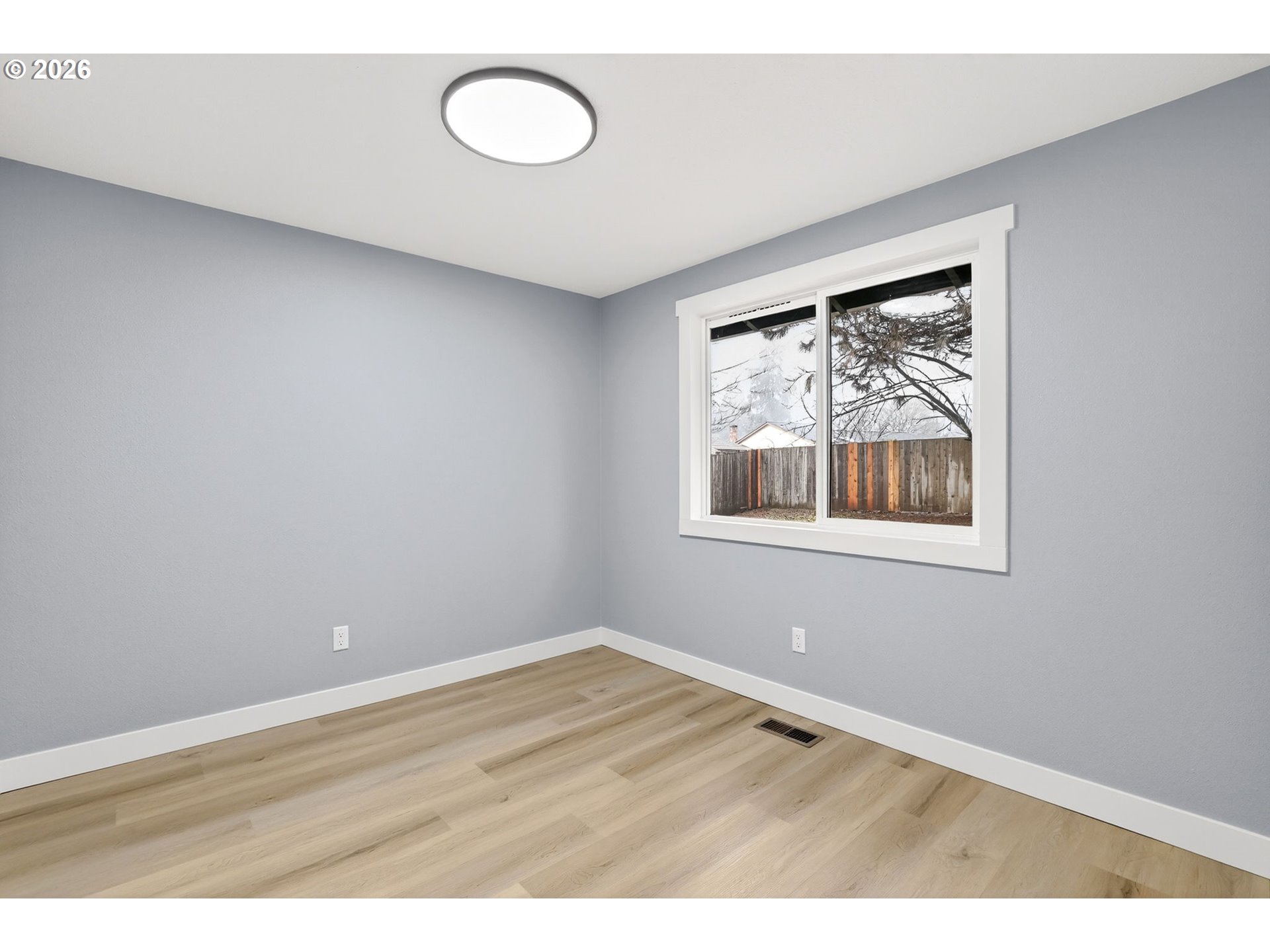 18830 Southwest Butternut Street Beaverton, OR 97078 - Photo 19 of 33 a view of an empty room with wooden floor and a window