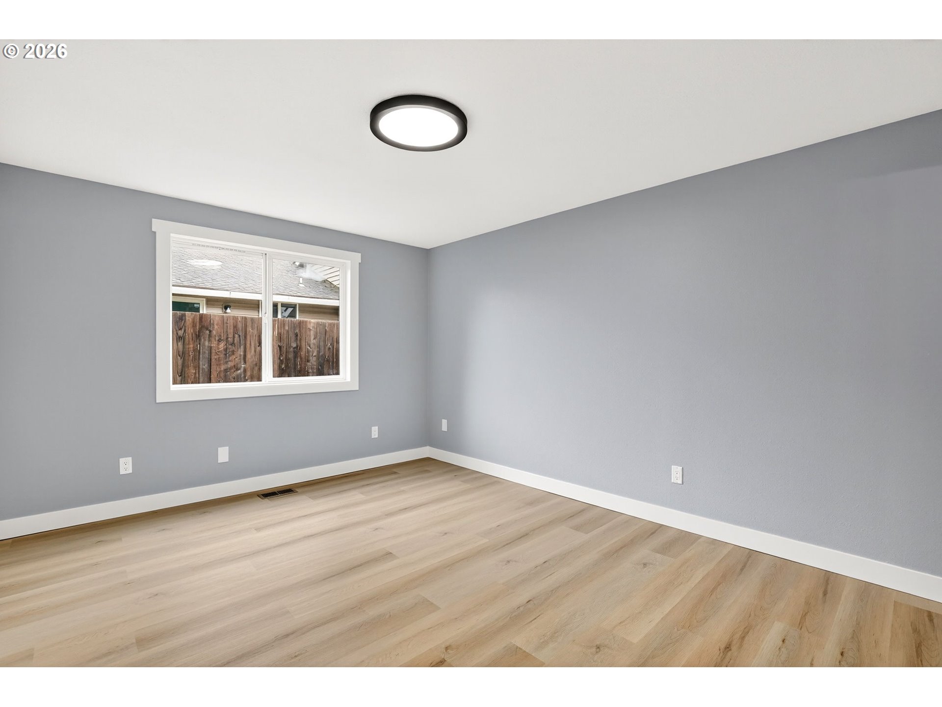 18830 Southwest Butternut Street Beaverton, OR 97078 - Photo 25 of 33 a view of an empty room with wooden floor and a window