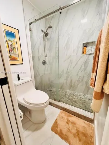 a bathroom with a toilet and a shower