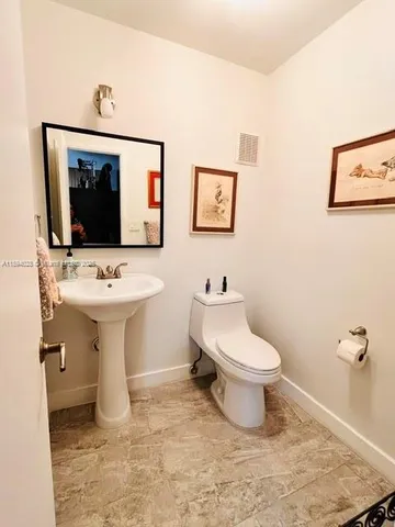 a bathroom with a toilet sink and mirror