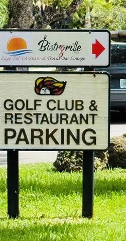 a street sign sitting on a wall next to a road