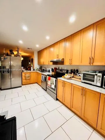 a kitchen with stainless steel appliances granite countertop a stove a sink and a refrigerator