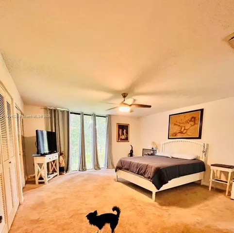 a bedroom with a bed a flat screen tv and balcony