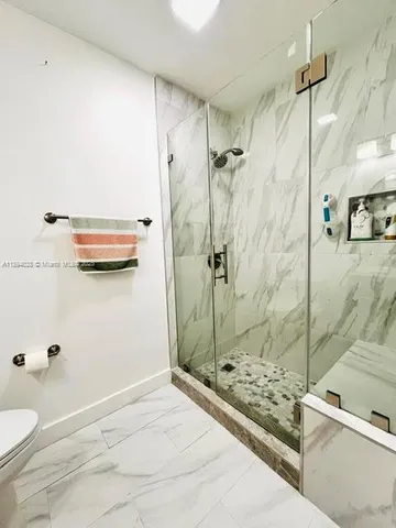 a bathroom with a granite countertop a white sink and a shower