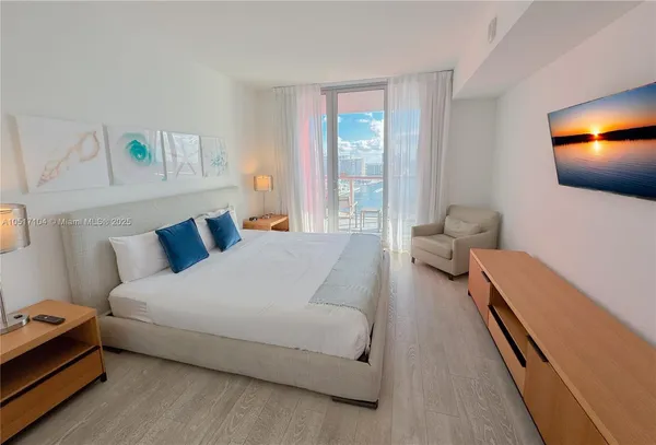 a bedroom with a bed and painting on the wall