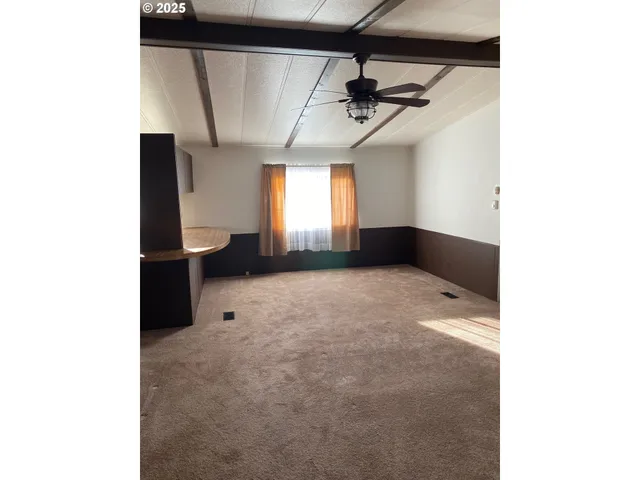 a very nice looking room with a large window and a ceiling fan