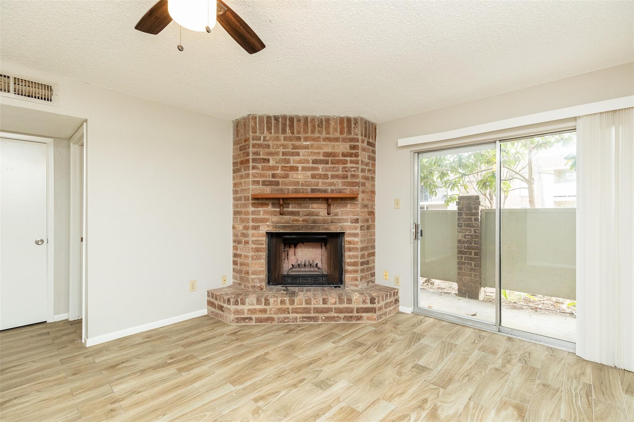 2800 Jeanetta Street, Unit 2805 Houston, TX 77063 - Photo 2 of 19 a view of an empty room with wooden floor and a fireplace