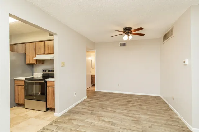a view of a kitchen with a stove cabinets and a ceiling fan