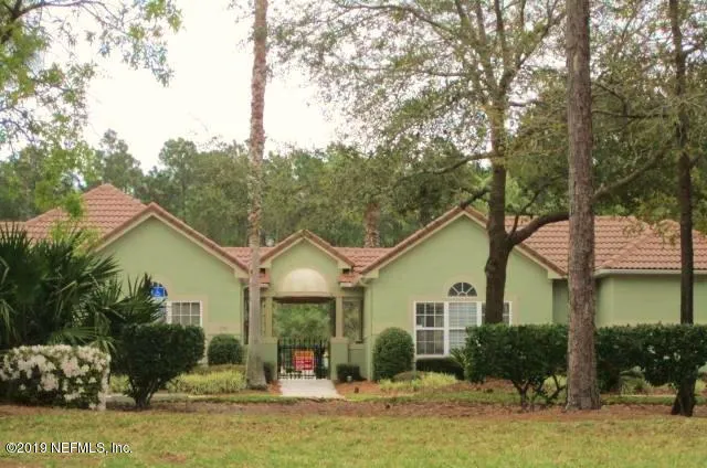a sign that is sitting in front of a brick house