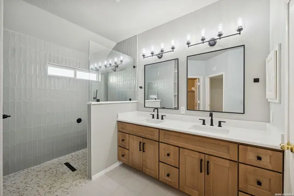 a bathroom with a double vanity sink and a mirror