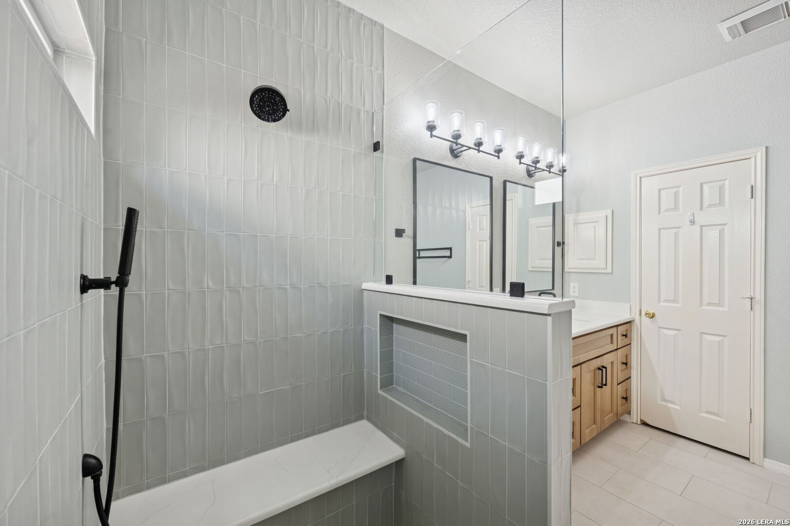 626 Rexton Lane San Antonio, TX 78258 - Photo 27 of 34 a bathroom with a double vanity sink a large mirror and shower