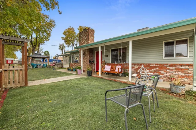 a backyard of a house with table and chairs