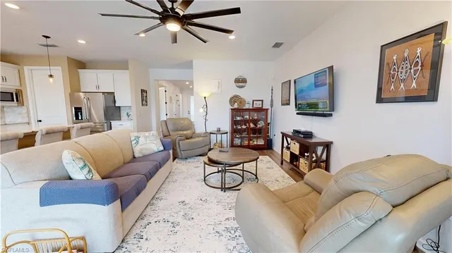 a living room with furniture kitchen view and a window