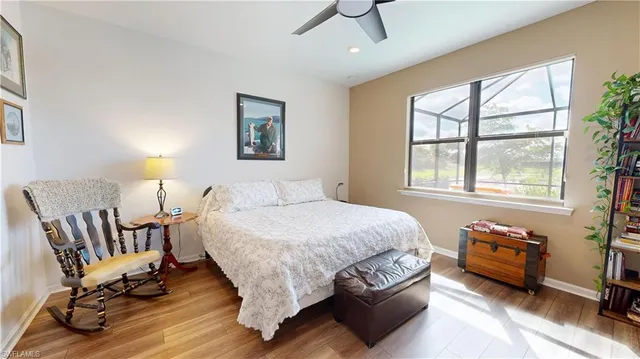 a bedroom with a bed a chair and next to a window